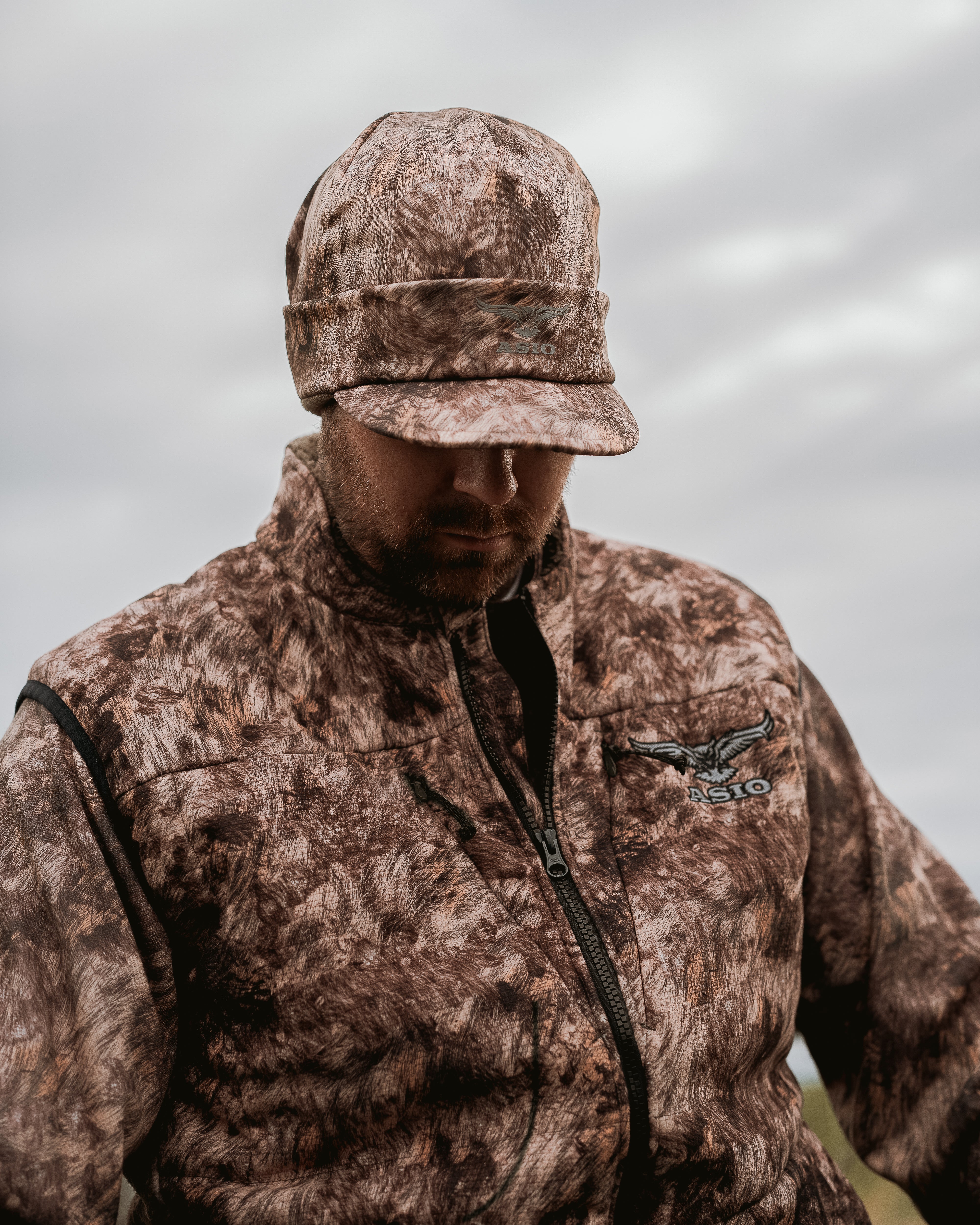 Hunter wearing ASIO Gear Heavyweight Vest in RAPX CAMO® with full-zip front and bowhunting collar design—built for bowhunters demanding warmth, mobility, and concealment.
