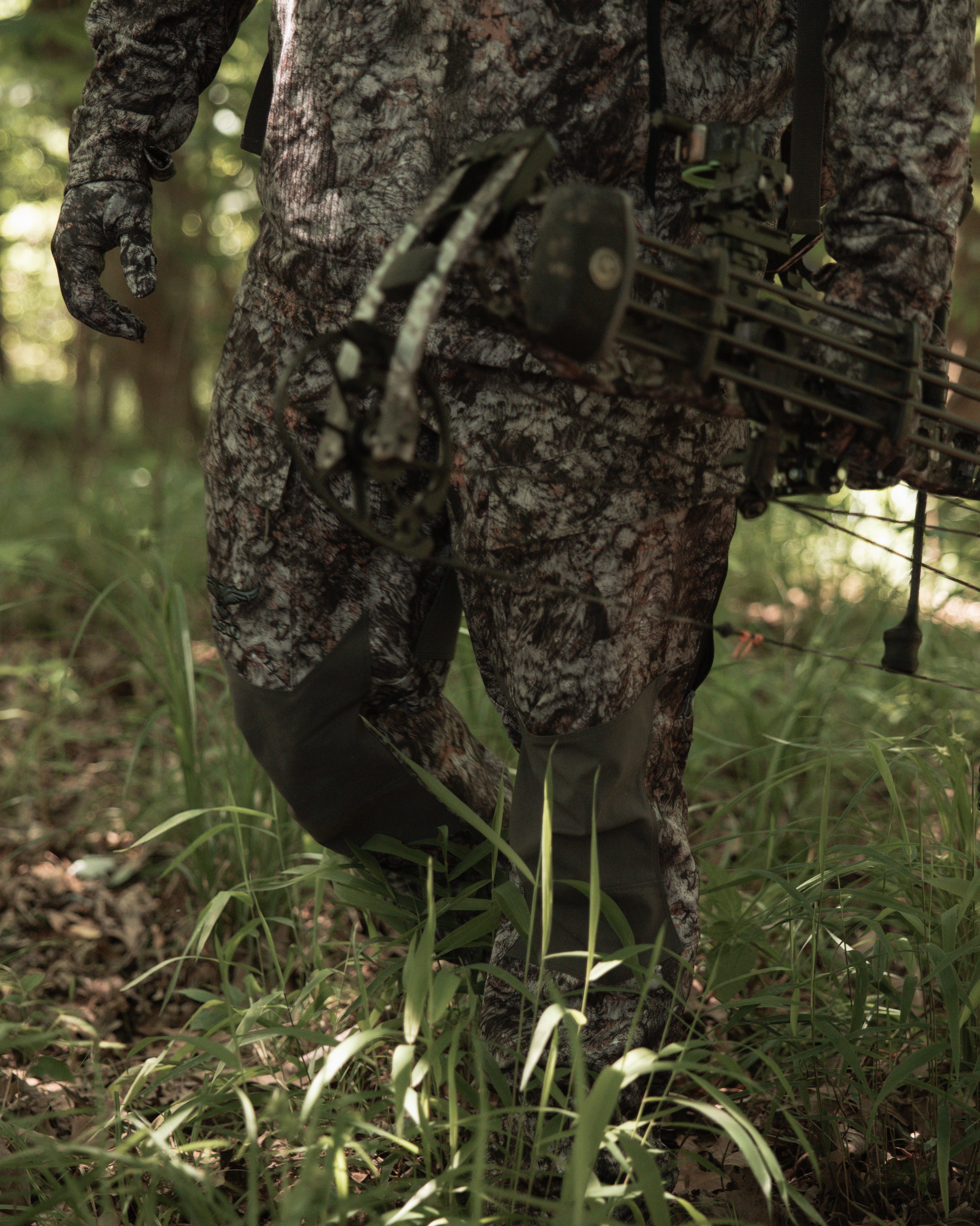 ASIO Gear Midweight Bomb Pant in RAPTOR camo shown in-action while bowhunting through hardwoods