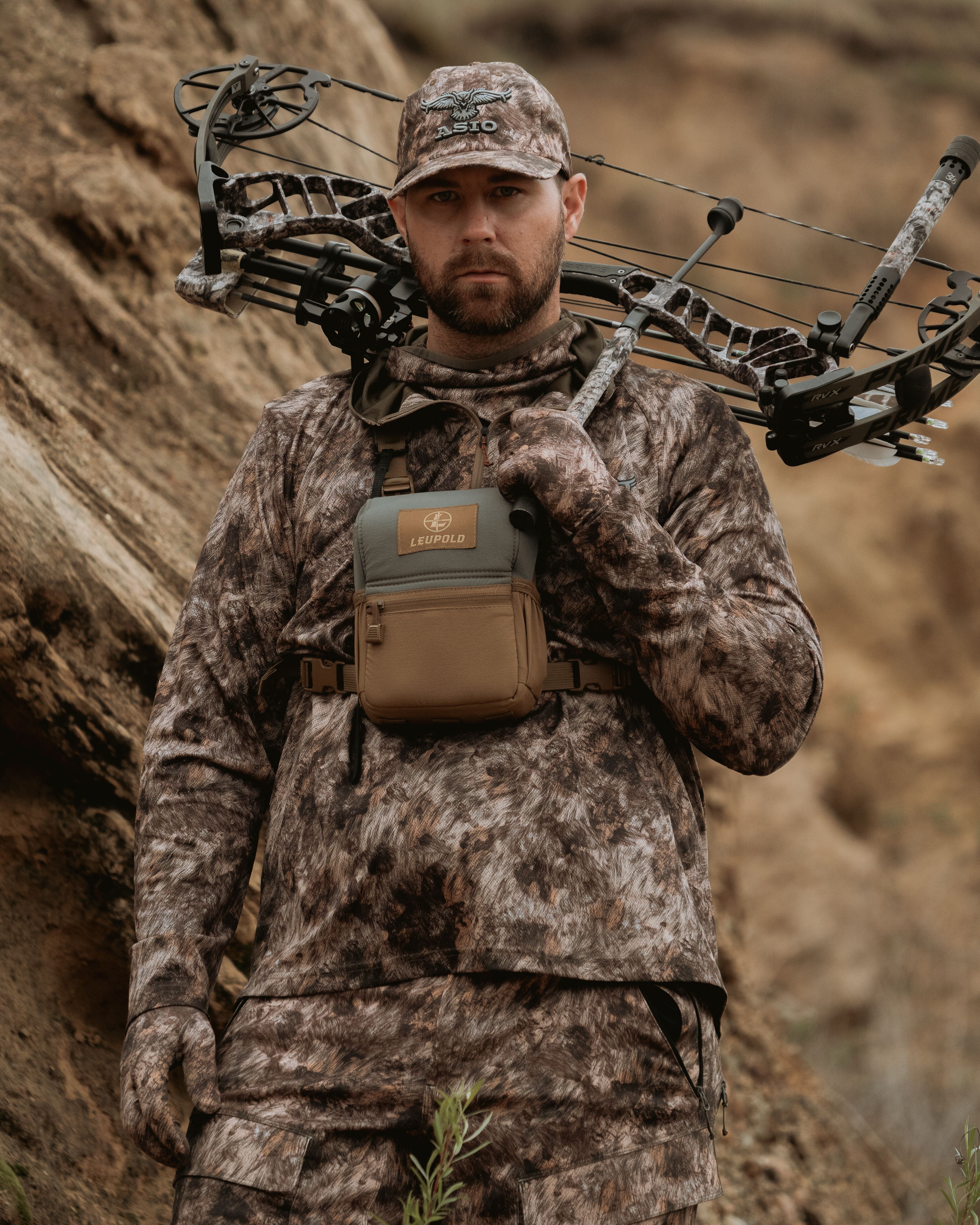 Hunter preparing bow with full ASIO Midweight Hoodie layering system in rapx Camo.