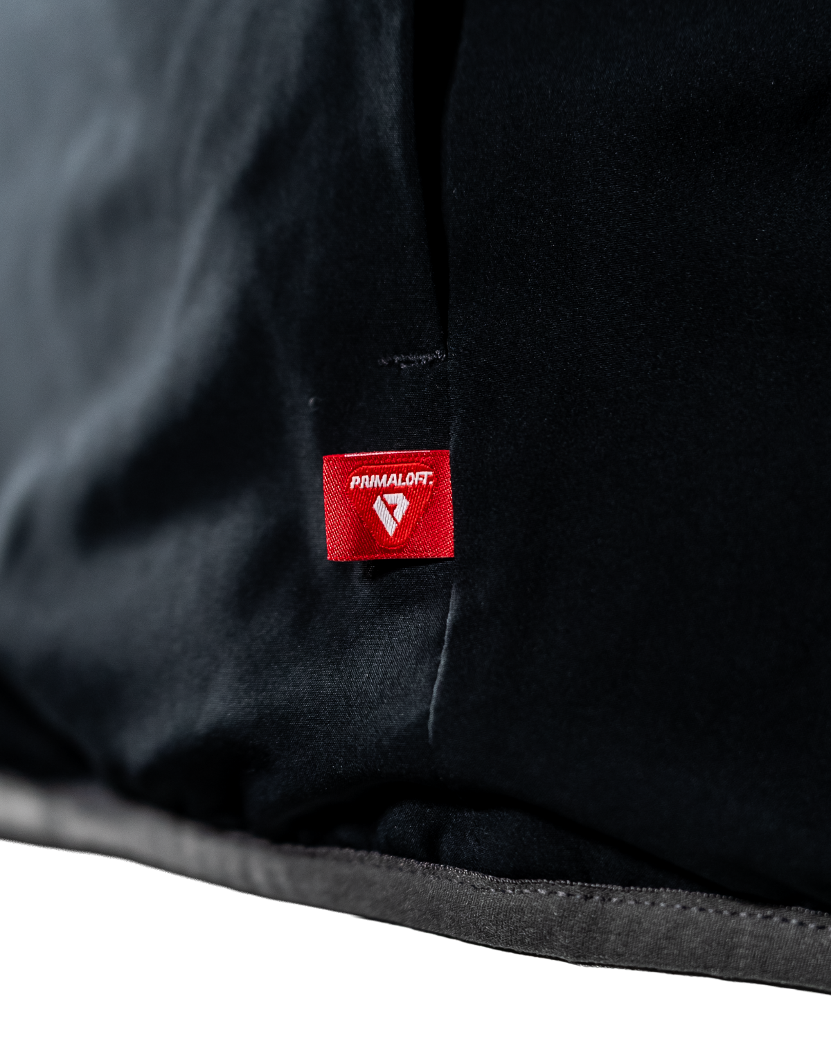 Hem detail of the black reversible side with the PrimaLoft insulation tag