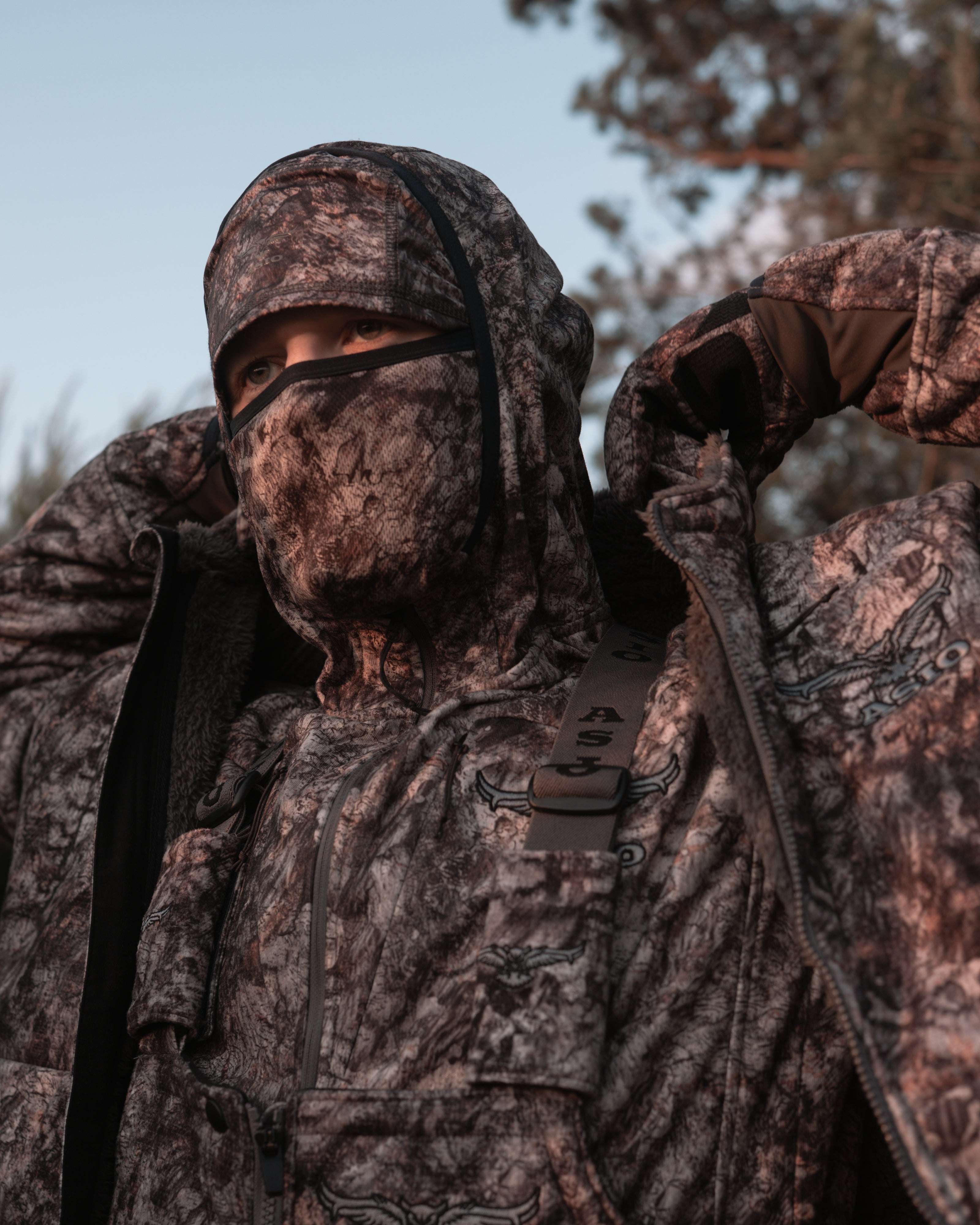 hunter showing off bowhunting collar on raptor camo mid season windproof sherpa hunting jacket
