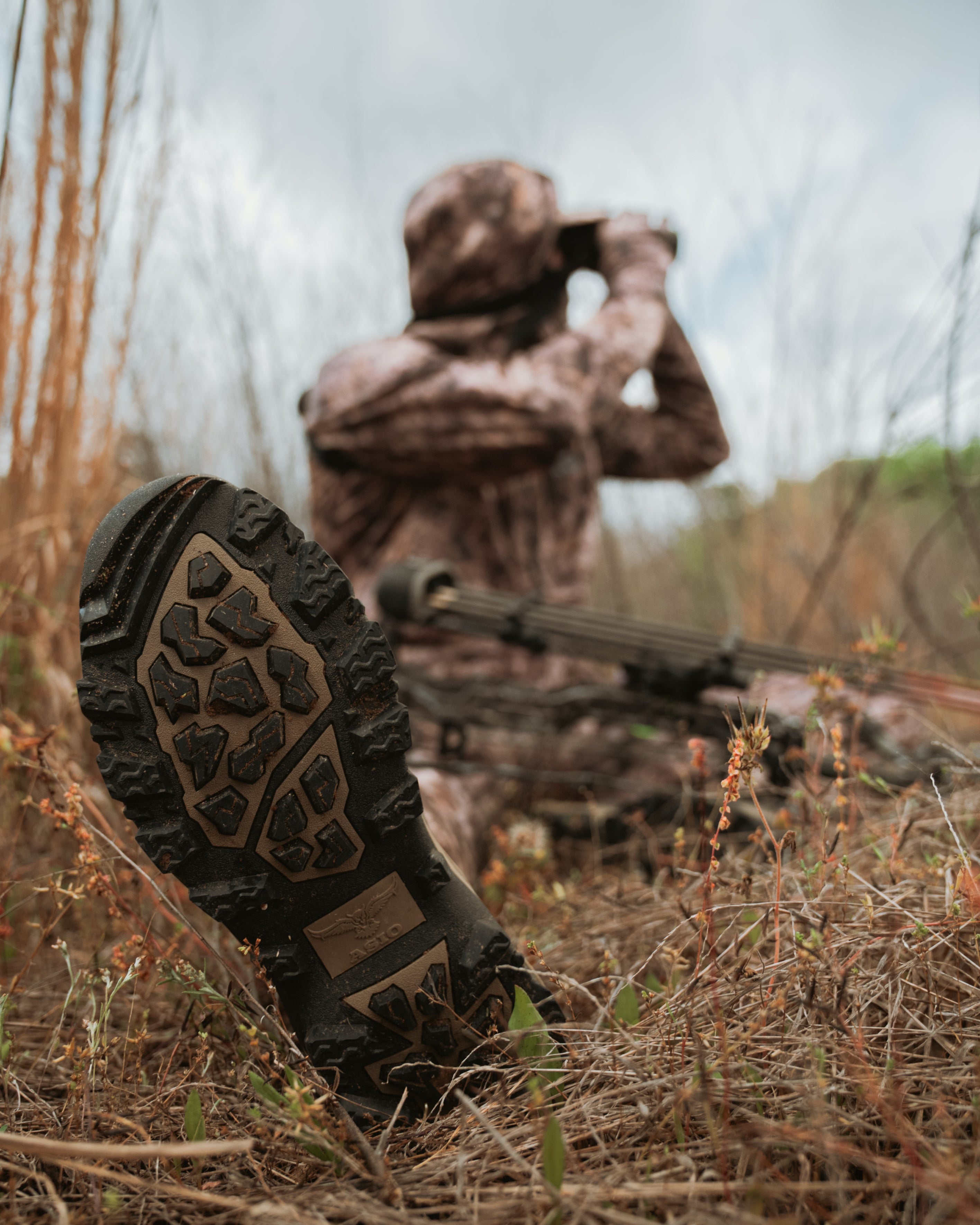 ASIO Gear Whitetail Pro Boot in RAPX camo worn while bowhunting and glassing from a concealed ground position