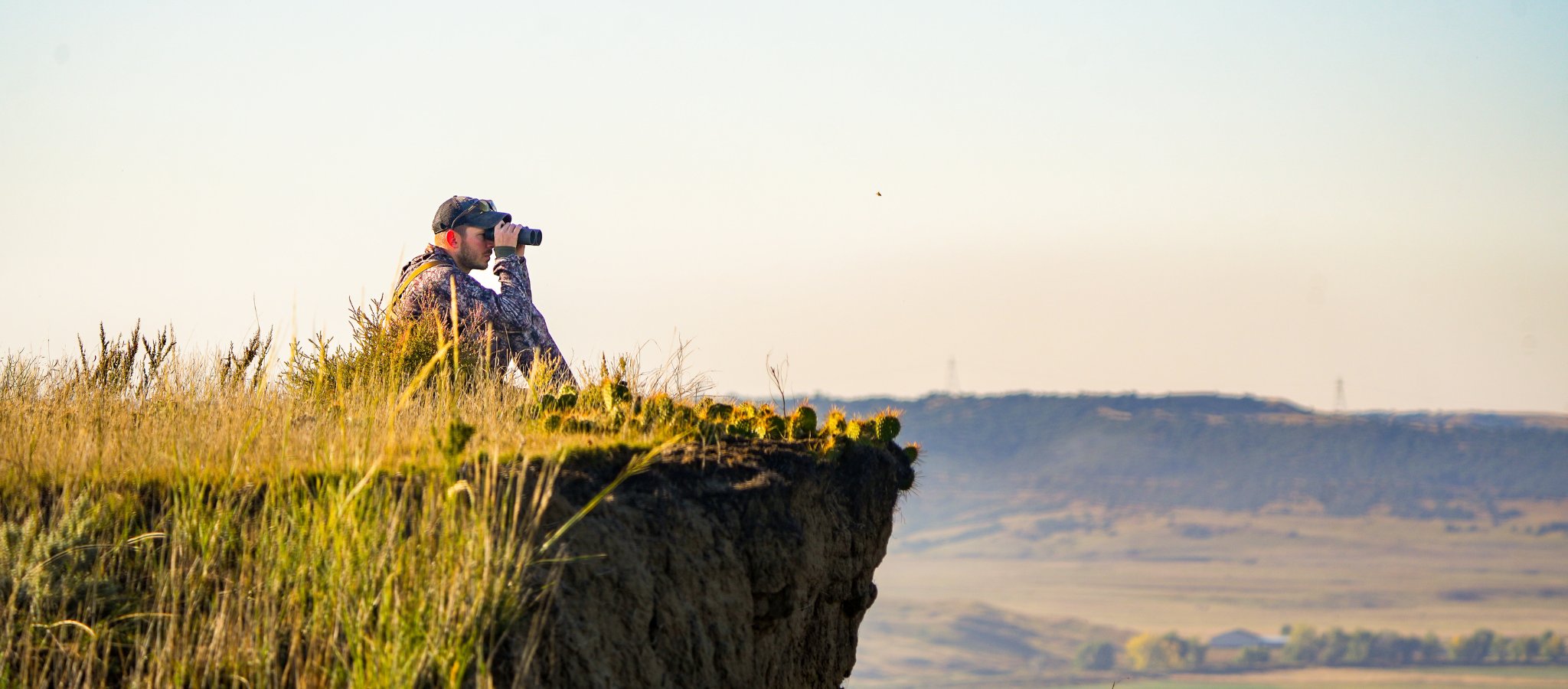 hunter glassing a valley wearing asio raptor camo