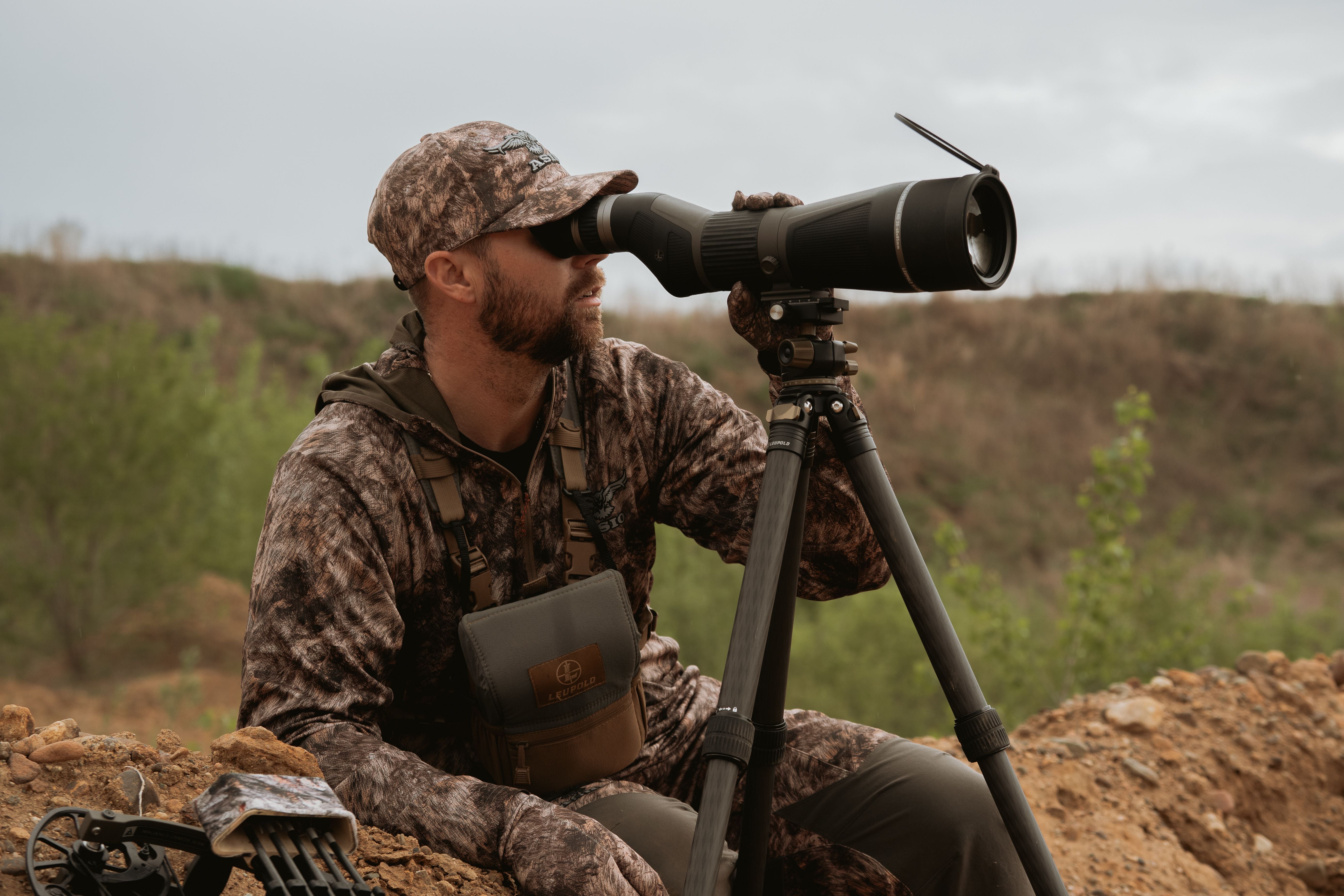 hunter wearing asio rapx camo using spotting scope to locate whitetails on western plains