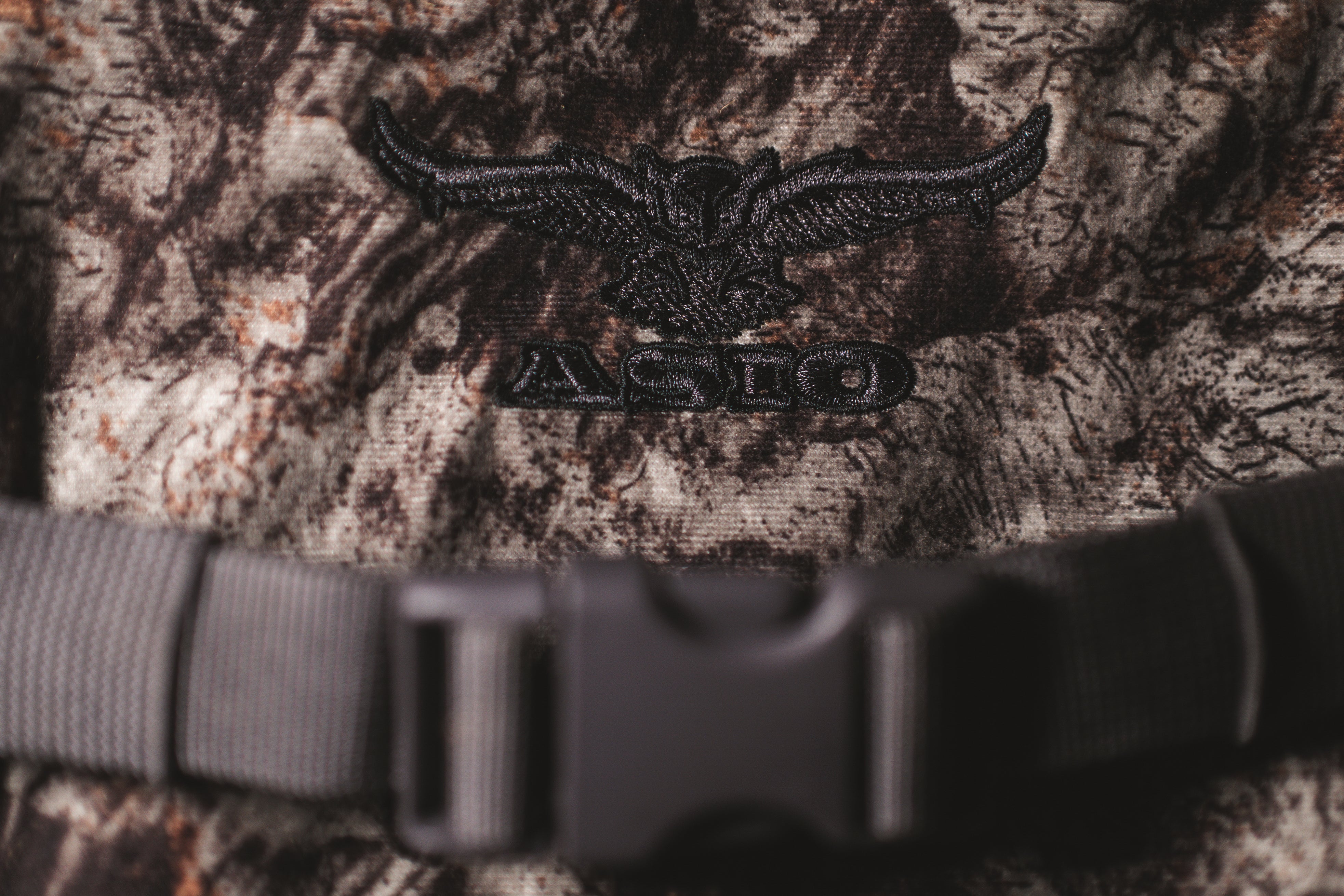 ASIO Gear embroidered logo on Raptor camo turkey hunting vest showing premium stitching and camo fabric detail