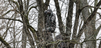 hunter at full draw wearing asio gear rapx camo in late season bow hunt - header promo