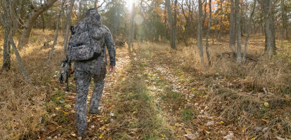 hunter walking in asio gear rapx camo for mid season bow hunt - header promo
